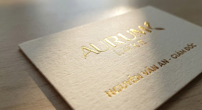 Cận cảnh logo ép kim vàng sắc nét trên danh thiếp giấy mỹ thuật